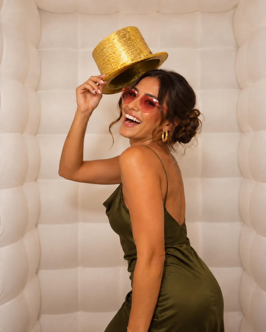 Invitada con sombrero dorado y lentes de corazón